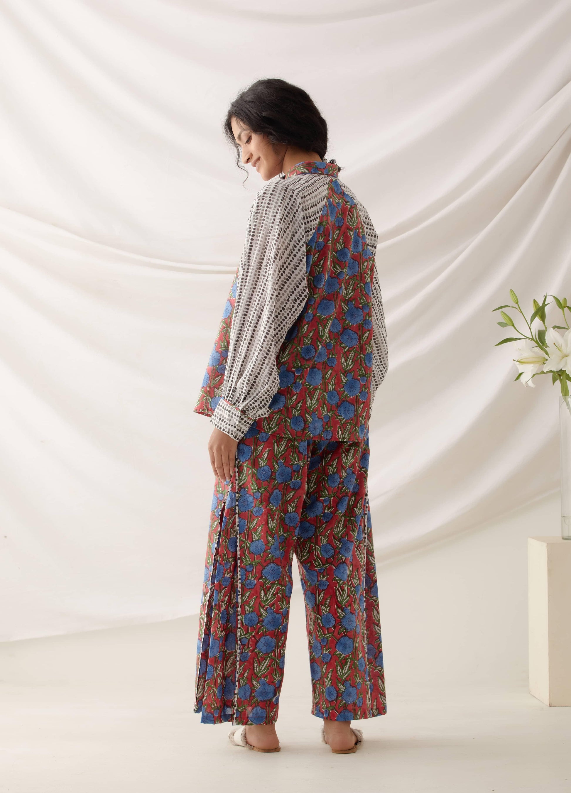 امرأة ترتدي مجموعة من الزهور الحمراء المطبوعة يدويًا مصنوعة من القطن بنسبة 100%.