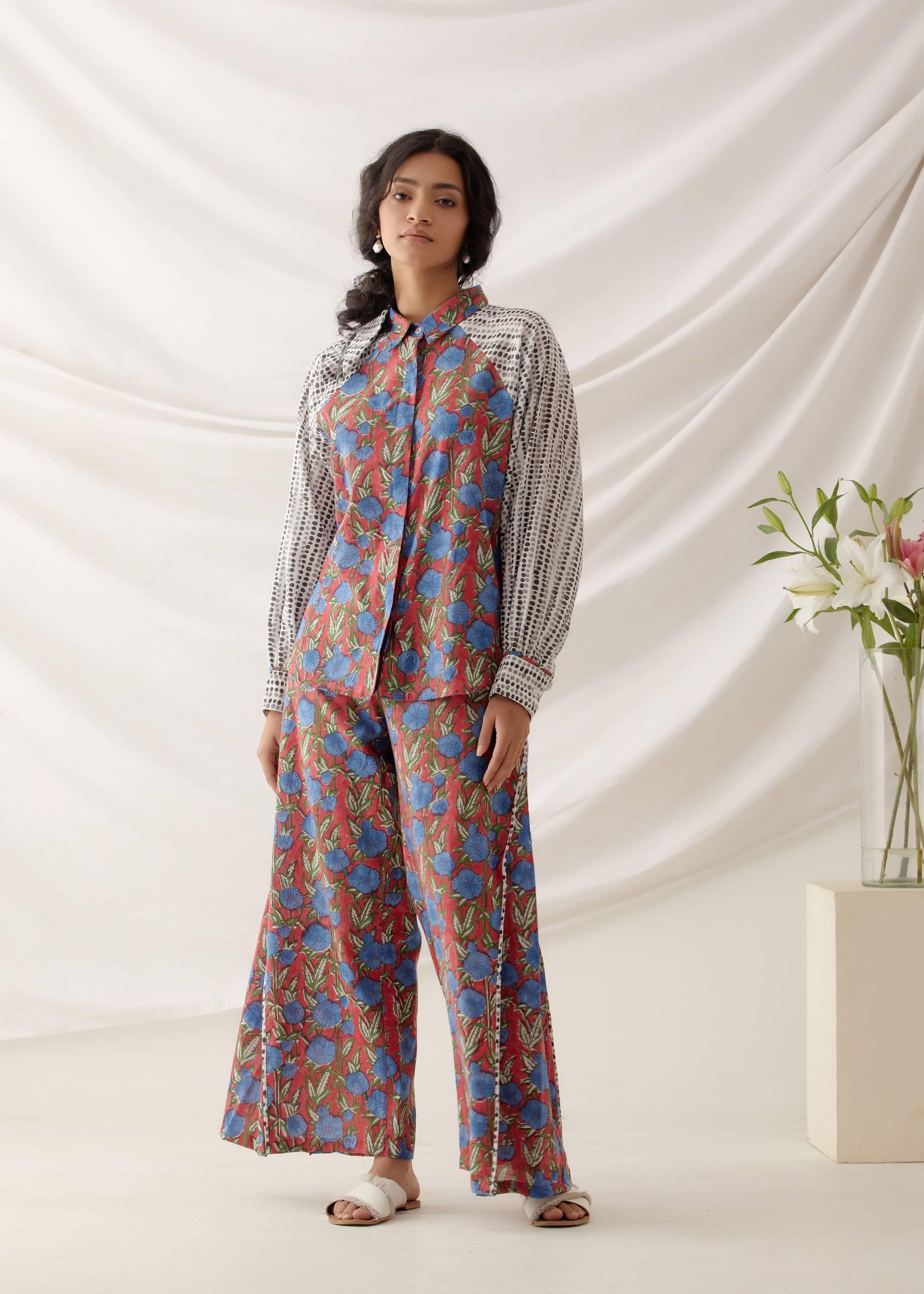 امرأة ترتدي مجموعة من الزهور الحمراء المطبوعة يدويًا مصنوعة من القطن بنسبة 100%.